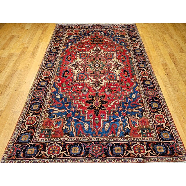 "This vintage Persian Heriz Serapi room-size rug, handwoven in the mid-20th century, is a striking example of village...