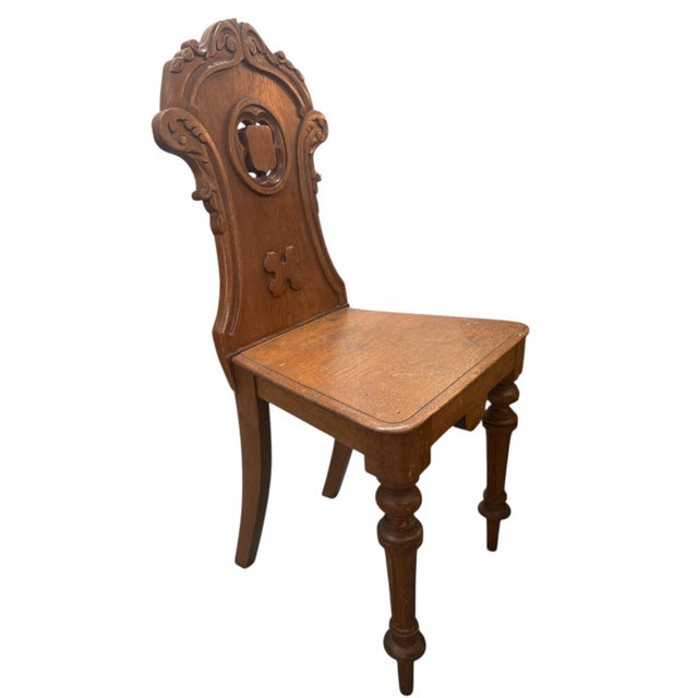 An exquisite 19th-century Victorian hall chair crafted from solid oak, featuring striking Gothic Revival architectural...