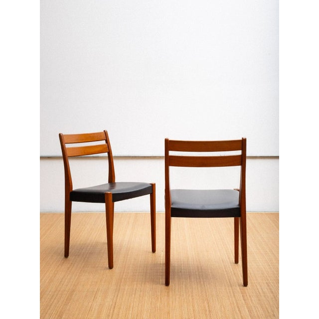 A pair of dining chairs by Svegards Markaryd. Teak frames and original black vinyl upholstery. Svegards Markaryd is a...
