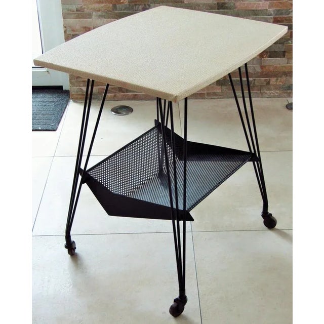 - Bar cart from Atelier Matégot - Produced in France in the 1950s - Black metal foot - Vinyl-coated tabletop - Wheels move...