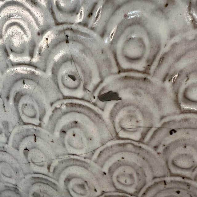 Tall oversized slab-built ceramic vessel. This piece features a stamped body and sculpted “wings” in a greyish white...