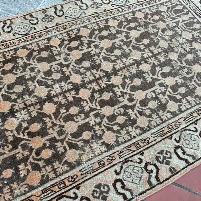 A striking example of East Turkestan weaving, this antique Khotan rug embodies the quiet sophistication and symbolic...