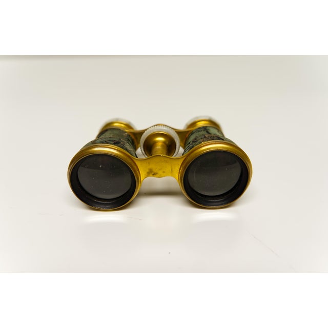 Antique early 20th century Colmont Paris opera glasses and a decorative matching case. Featuring a brass construction and...