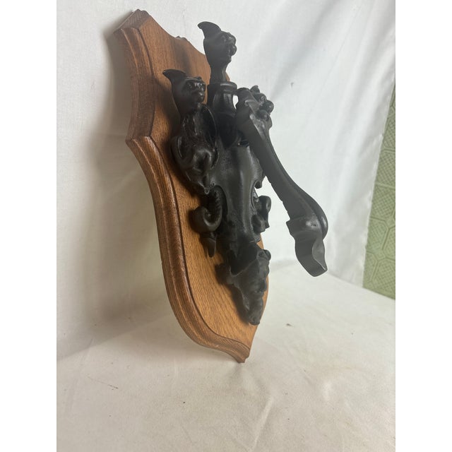 This fascinating antique brass door knocker depicts three gargoyles, which are sure to scare off any intruders! This piece...