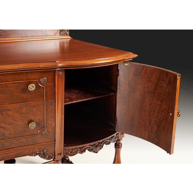 Antique walnut sideboard featuring beautifully figured walnut burl panels, decorative carvings, and elegant turned legs...