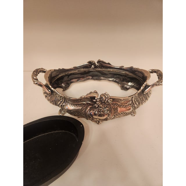 Overflowing with rococo curves and elaborate relief work, this decorative centerpiece is a true showstopper. Twin stylized...