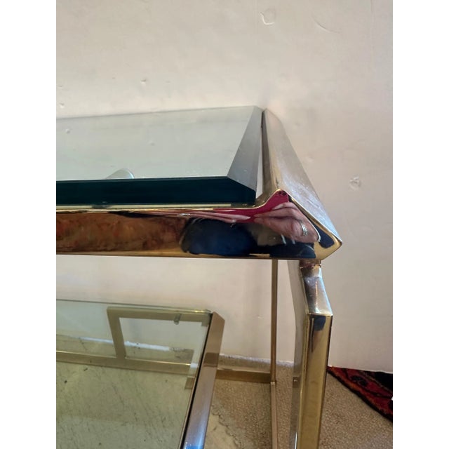 Glamorous well made brass and beveled glass two tiered console having lower floating glass tier. Dabagian