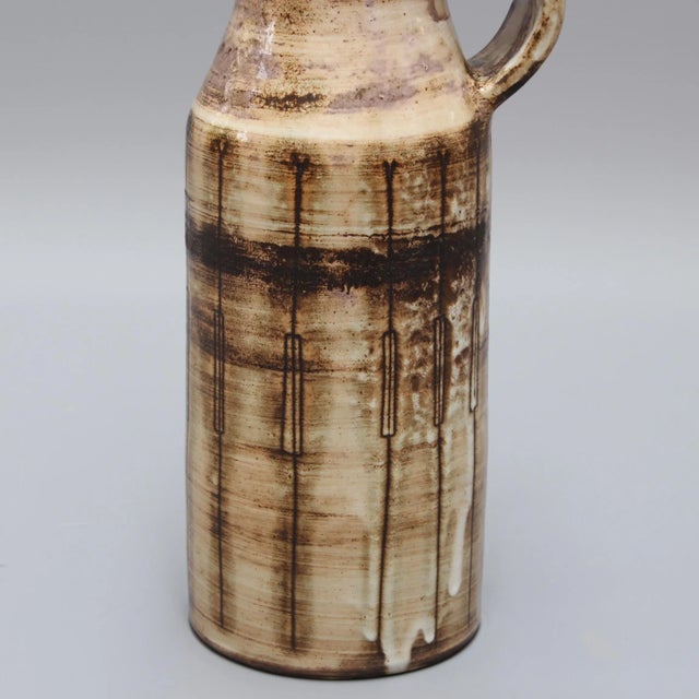 This mid-century ceramic vase from around the 1960s was designed by Jacques Pouchain (1925 - 2005). The milk-pitcher-...