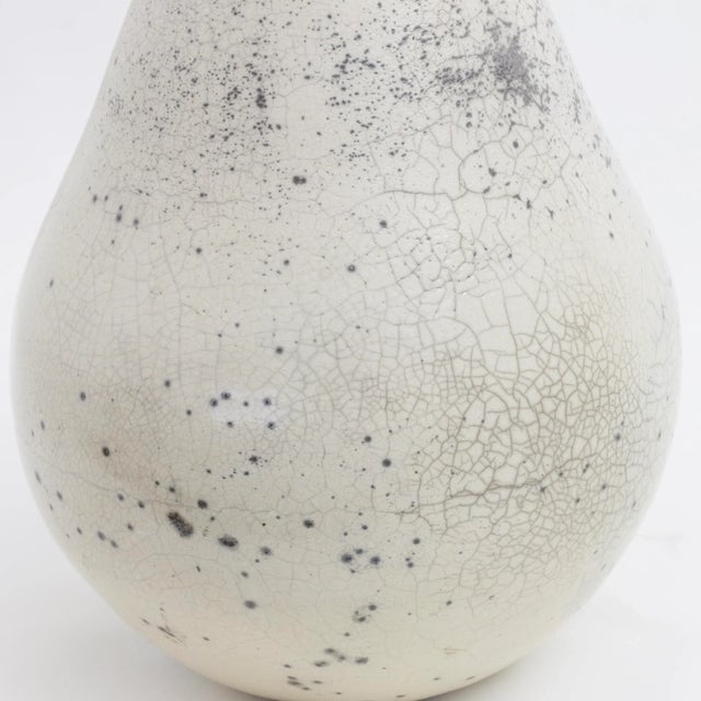 Minimalist and fluid lines outline the silhouette of this sculpture, unique objet d'art deftly handcrafted of ceramic by...