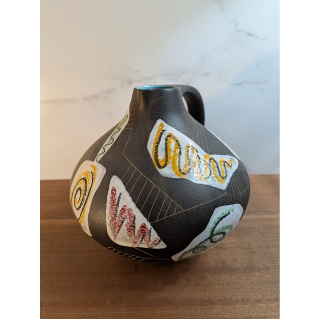Matte Black Ruscha vase with decorative white glaze and hand painted designs. Striking contrast in texture and color....