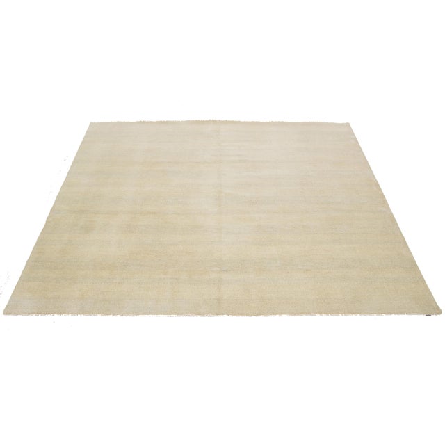 This hand-knotted Square wool rug showcases a modern design featuring a thoughtfully crafted blend of beige tones,...