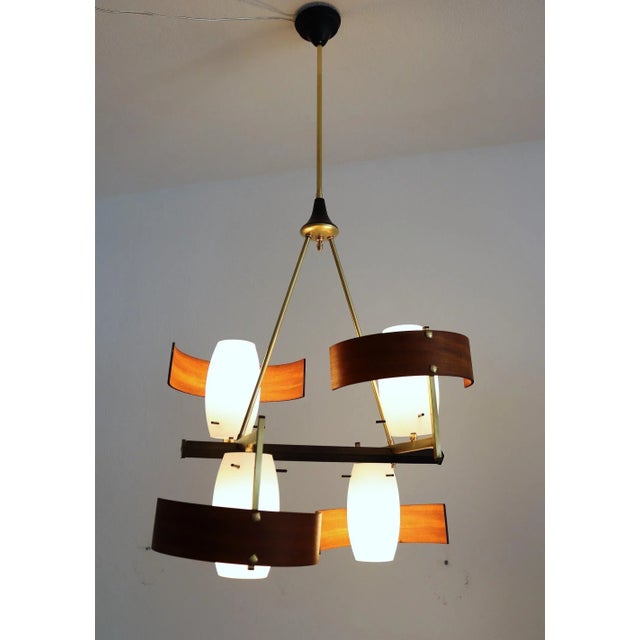 Beautiful Italian modernist chandelier made of teak and 4 white glass shades with brass and metal lamp frame and many...