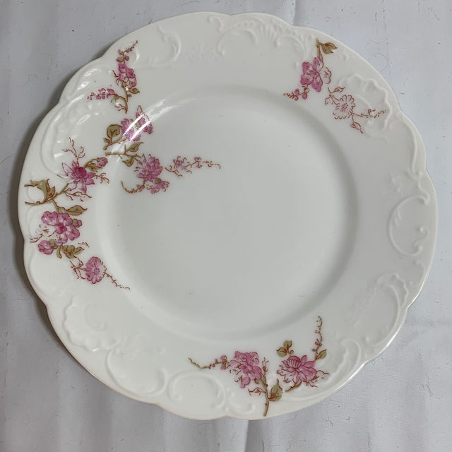 This is a vintage dinner plate set produced by Haviland & Company in Limoges, France, featuring a pink floral swag...