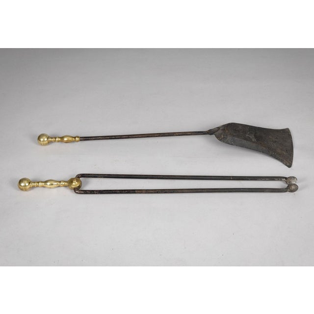 Pair good quality brass and iron fireplace tools; a shovel and tongs. The handles are nicely turned.