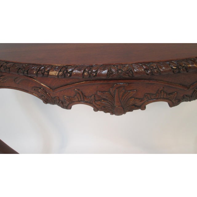 This is a beautiful highly carved half console table. The table should be attached to a wall. The base apron and legs are...