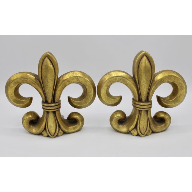 A stunning pair of golden gilt resin Fleur de Lis bookends, circa 1970s. This is a lovely, bright pair.