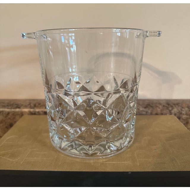 Elegant vintage cut glass ice bucket featuring a diamond pattern and small side handles. The clear glass catches the light...