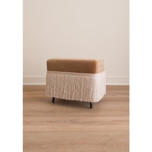 The Hutton is a cotton velvet upholstered stool, finished with a fringe trim in Dune. Crafted from richly variegated...
