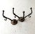 Antique bronze double arm wall hooks features a dark patina, indicative of its age. It is designed with a decorative,...