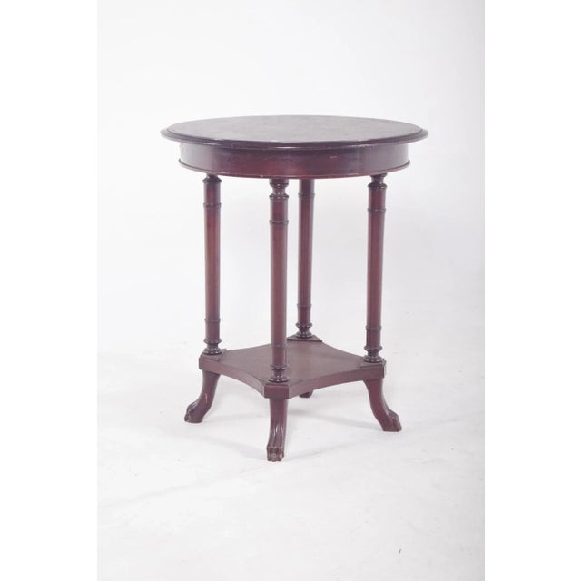 Round coffee table. with a smooth top, resting on four elegant turned legs connected to each other by a bottom rail in a...