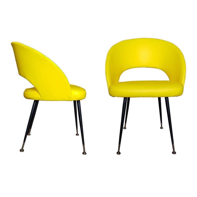 Couple of armchairs upholstered in yellow leatherette, legs of brass and steel tubs. Manufactured in the 1950s.