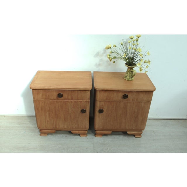 1940s/50s bedside table or side table, made of solid oak with natural oak veneer, some parts brushed. The cabinets are...