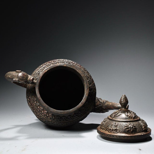 This substantial ewer is masterfully crafted from heavy solid copper, featuring incredibly intricate high-relief...