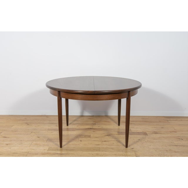 This round extendable dining table was produced by G-Plan in the 1960s. The table has profiled reinforced edges of the...