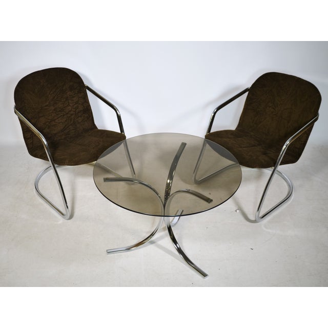 Cantilever set consisting of two armchairs and a round coffee table from the 1970s. Chrome-plated tubular steel frame with...