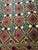 Hand-embroidered Suzani panel from Uzbekistan — a gold lattice over a russet ground, set with teal, navy and ivory...