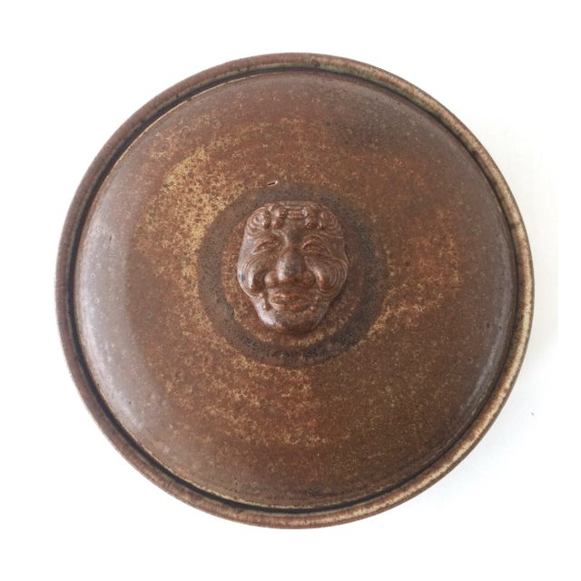 Here is a large stoneware dutch oven. This unique handmade pottery piece has a stylized Asian face for the lid handle....