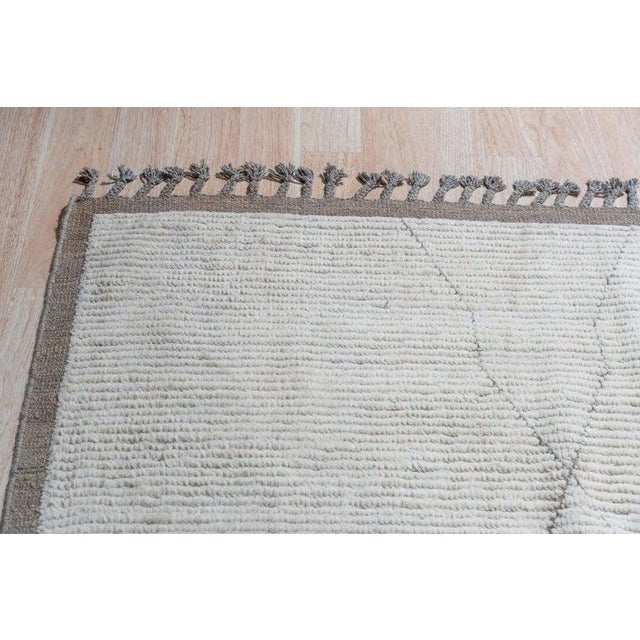 This hand knotted pile rug is crafted from wool and features a primary color palette of ivory, beige, cream, and white. As...