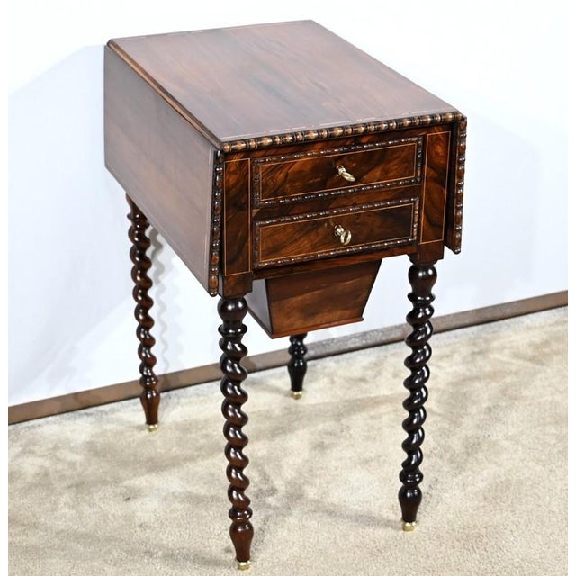This table opens on one side with two drawers whose veneer fronts are highlighted by fillets and a projecting molding...