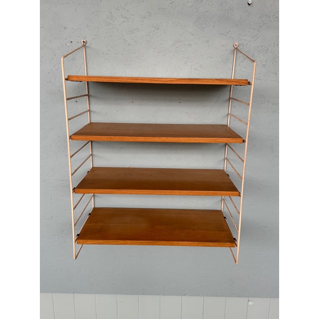 Scandinavian-made bookcase from the 1960s. This shelving unit consists of a lateral metal structure on which the oak...