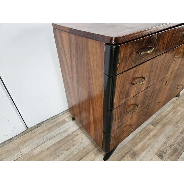 An elegant 1940s Art Deco dresser, featuring a refined mahogany burl veneer that highlights the natural grain of the wood....