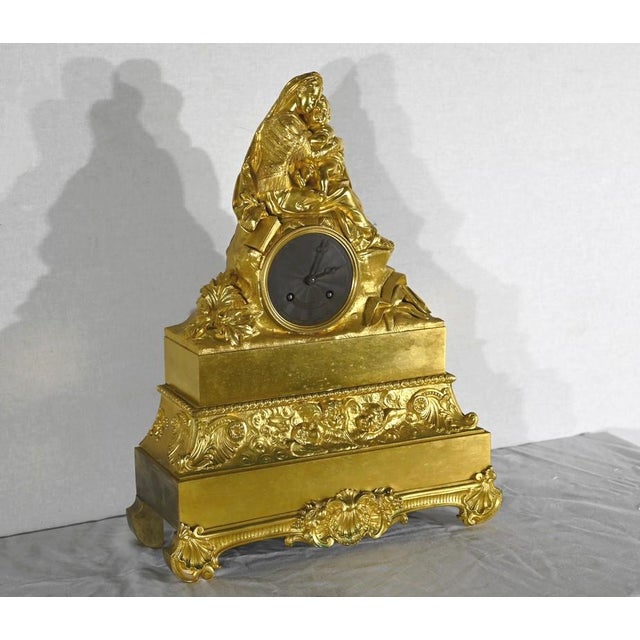 Stated rectangular clock, with a thread suspension mechanism, in gilded bronze, representing "the virgin with the chair",...