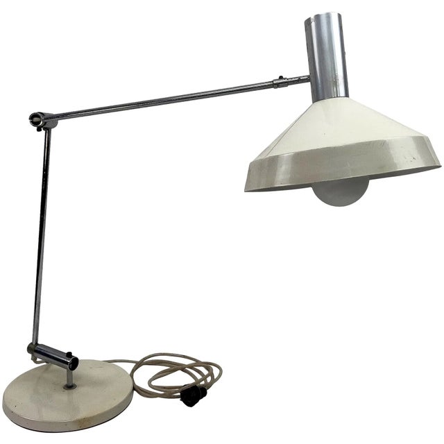 Modernist articulating table lamp designed by Rosemarie & Rico Baltensweiler. Features a weighted metal base, adjustable...
