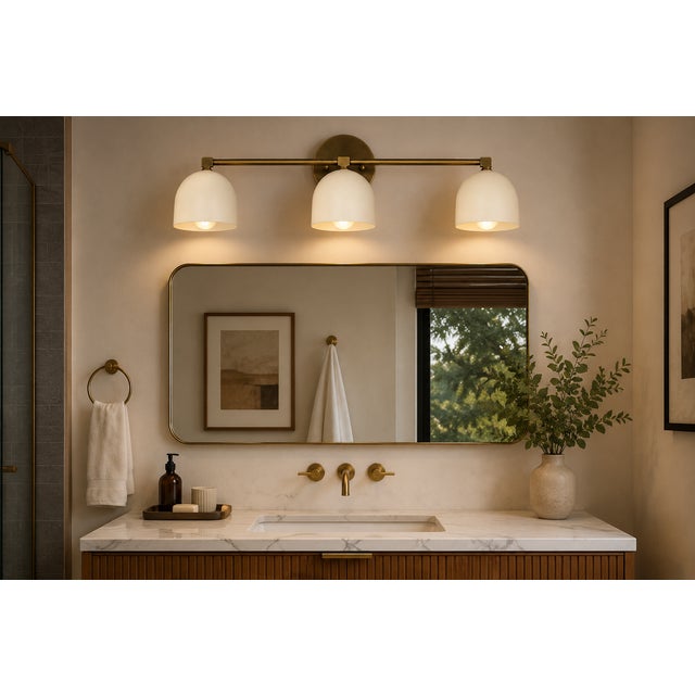 Crafted from solid brass, this handcrafted three-light wall sconce features a clean horizontal profile with three softly...