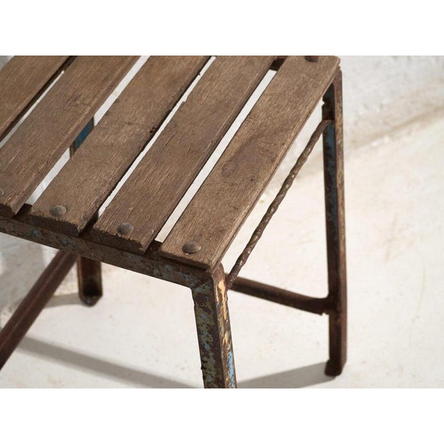 This antique industrial stool in pine wood and iron is an industrial seat with a tubular iron frame and a pine slatted...