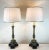 This elegant pair of antique lamps have lovely bases in silver with gilt accents. The custom white shades beautifully...