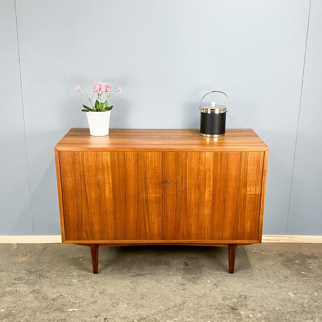 A simple yet elegant sideboard – made in Germany with beautiful details such as the period-typical, tapered legs in dark...