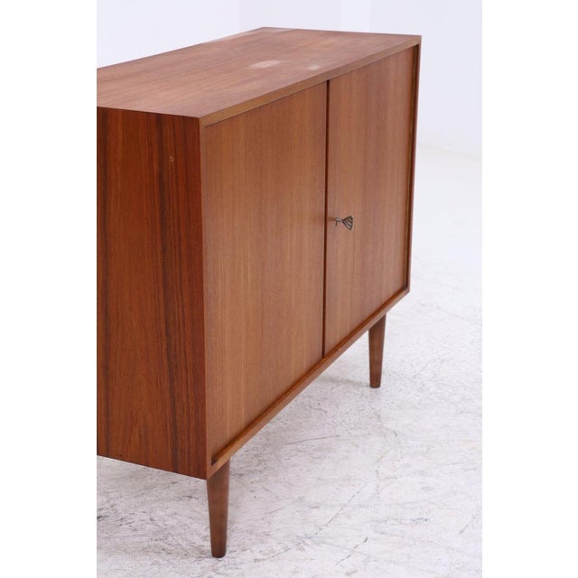 Vintage chest of drawers from Musterring with beautiful teak grain. The understated design and tapered legs give the piece...