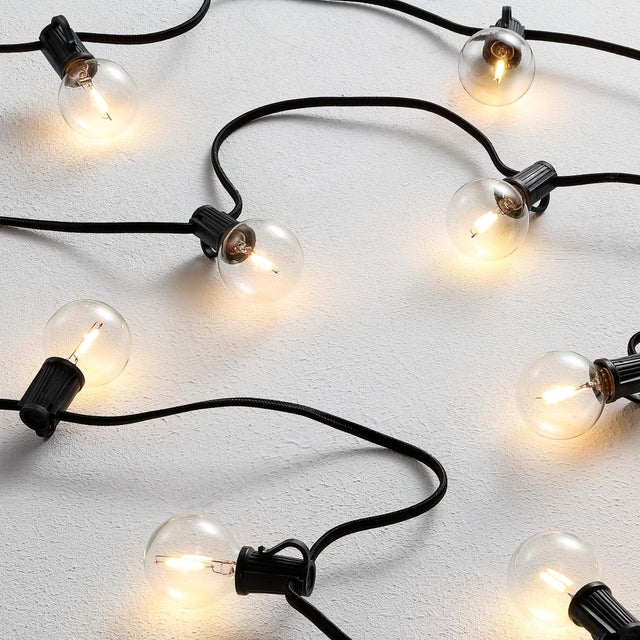 Illuminate your outdoor space with the Leigh 10 Light 120 Inch Black Metal Glass Plastic Outdoor String Light. This...