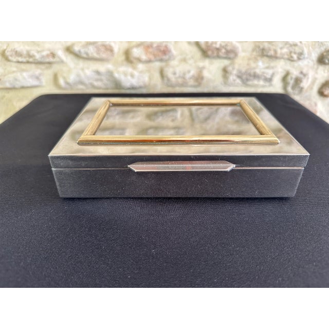 Rare box with double compartments, beautifully made, covered in shiny chrome, brass frieze and wooden interior. This box...