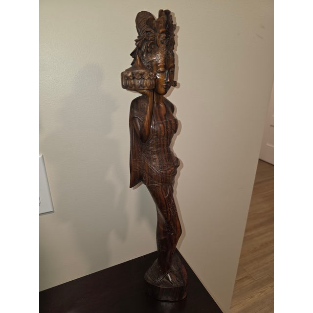 An extraordinary, gallery-scale mid-century Balinese modernist realism sculpture depicting a temple maiden carrying a...