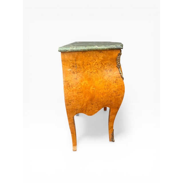 A striking pair of French Louis XV style bombe nightstands, showcasing dramatic curves, richly figured burl wood veneer,...