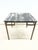 A sophisticated Hollywood Regency dining or game table featuring a richly veined black top supported by an aged brass...