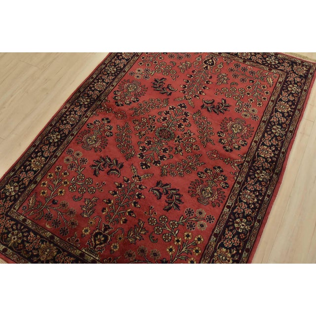 A traditional Sarouk rug hand-knotted with an all-wool pile on a cotton foundation. This finely woven oriental rug...