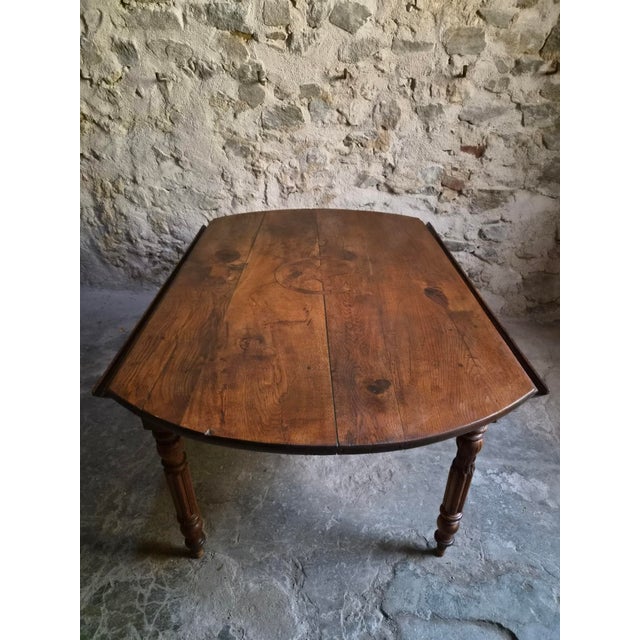 An antique French oak drop leaf dining table dating from around 1850–1880. Made from solid oak, the table has a round top...