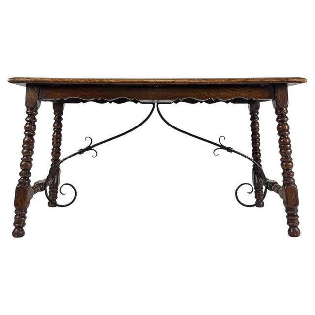 A distinctive early 20th-century English coffee table, finely crafted from oak and distinguished by its elaborate bobbin-...